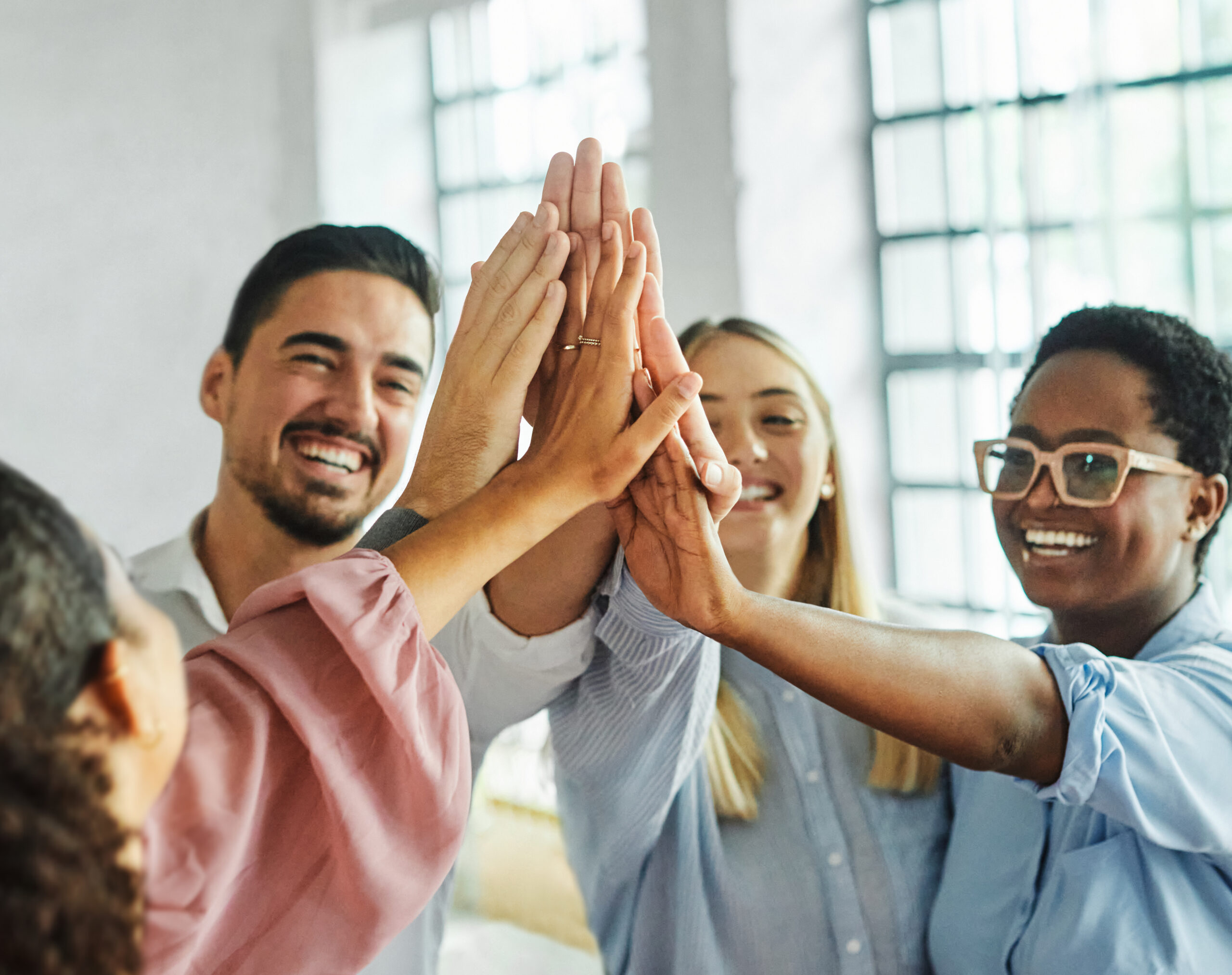a group of people all high fiving their hands together.